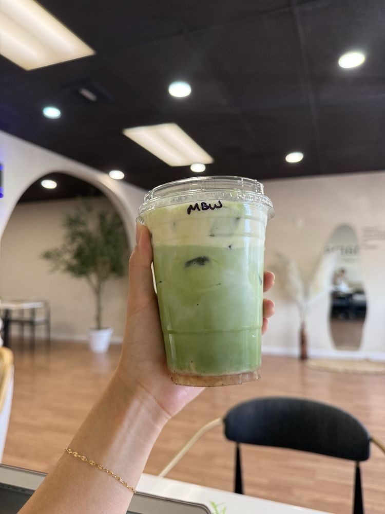 Matcha banana latte held up outside