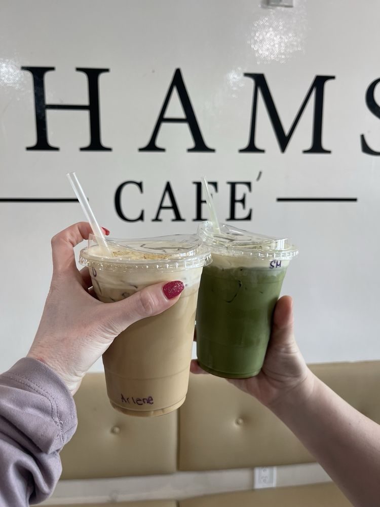 Two lattes in front of the Shams Cafe sign